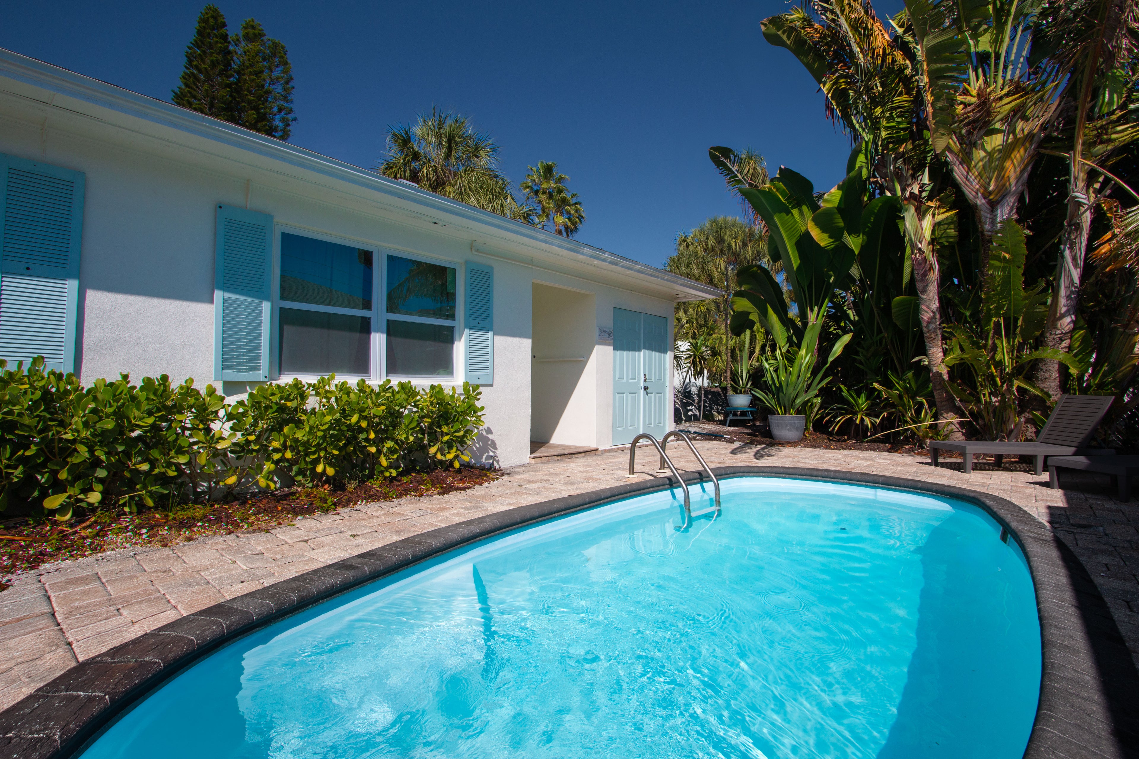 Private pool view at Sea Glass Beach Compound by Golden Coast Rentals featuring tropical landscaping, luxury Clearwater Beach vacation rental accommodations, and relaxing Gulf Coast outdoor living near the beach