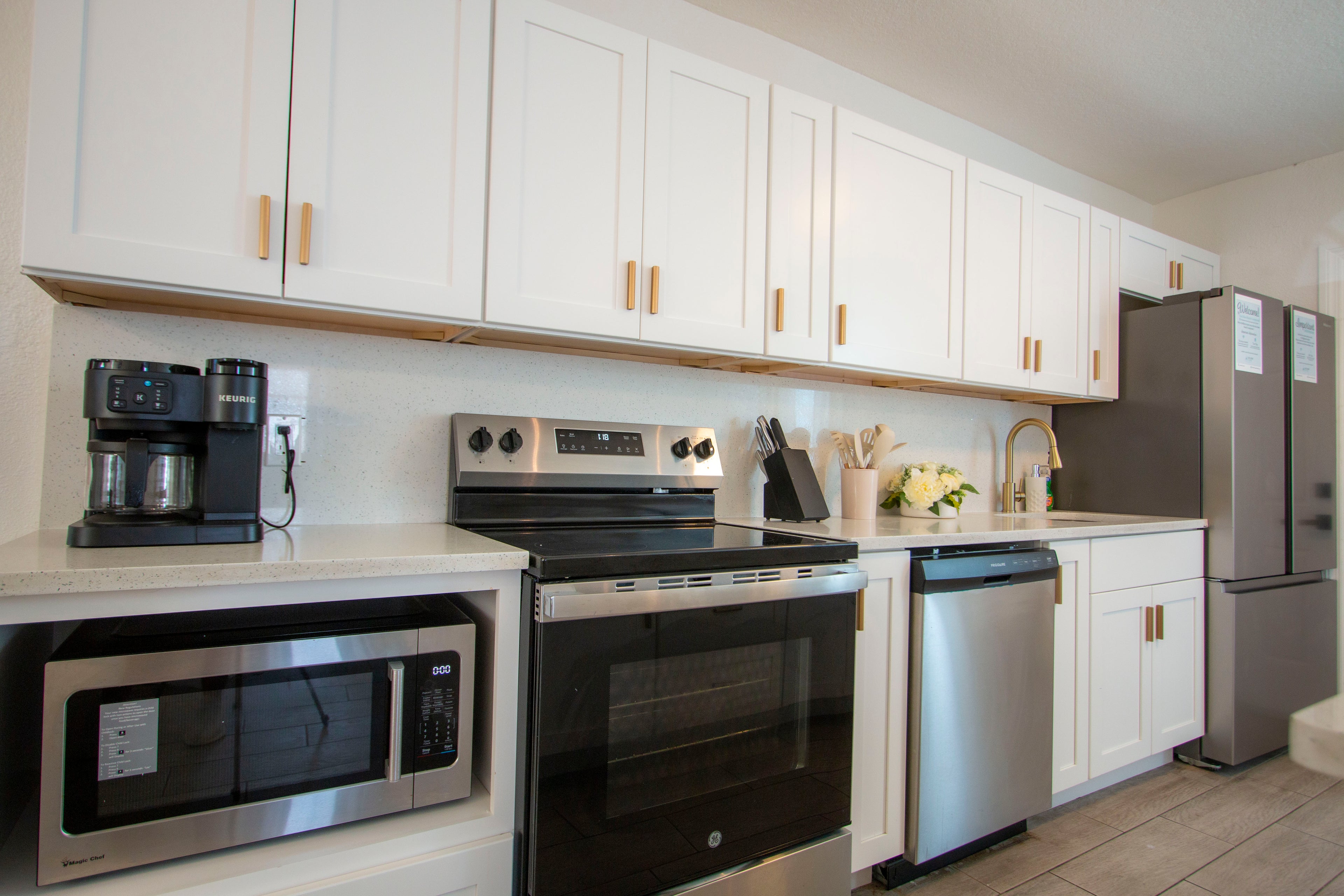 Modern kitchen inside Sea Glass Beach Compound featuring stainless steel appliances, coastal cabinetry, open-concept design, and luxury Clearwater Beach vacation rental accommodations for large groups