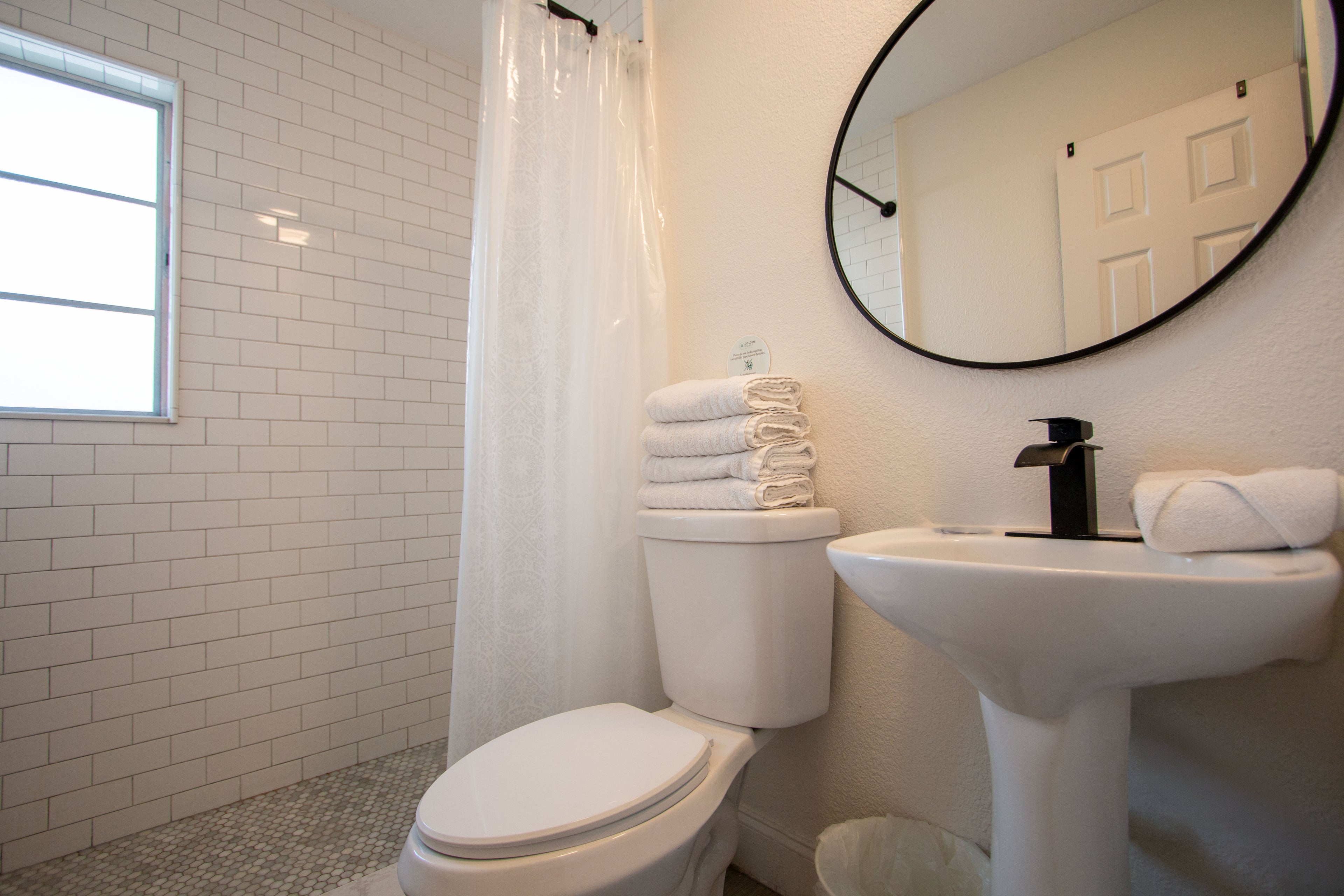 Modern coastal bathroom at Sea Glass Beach Compound featuring walk-in shower, elegant vanity, bright natural lighting, and luxury Clearwater Beach vacation rental accommodations