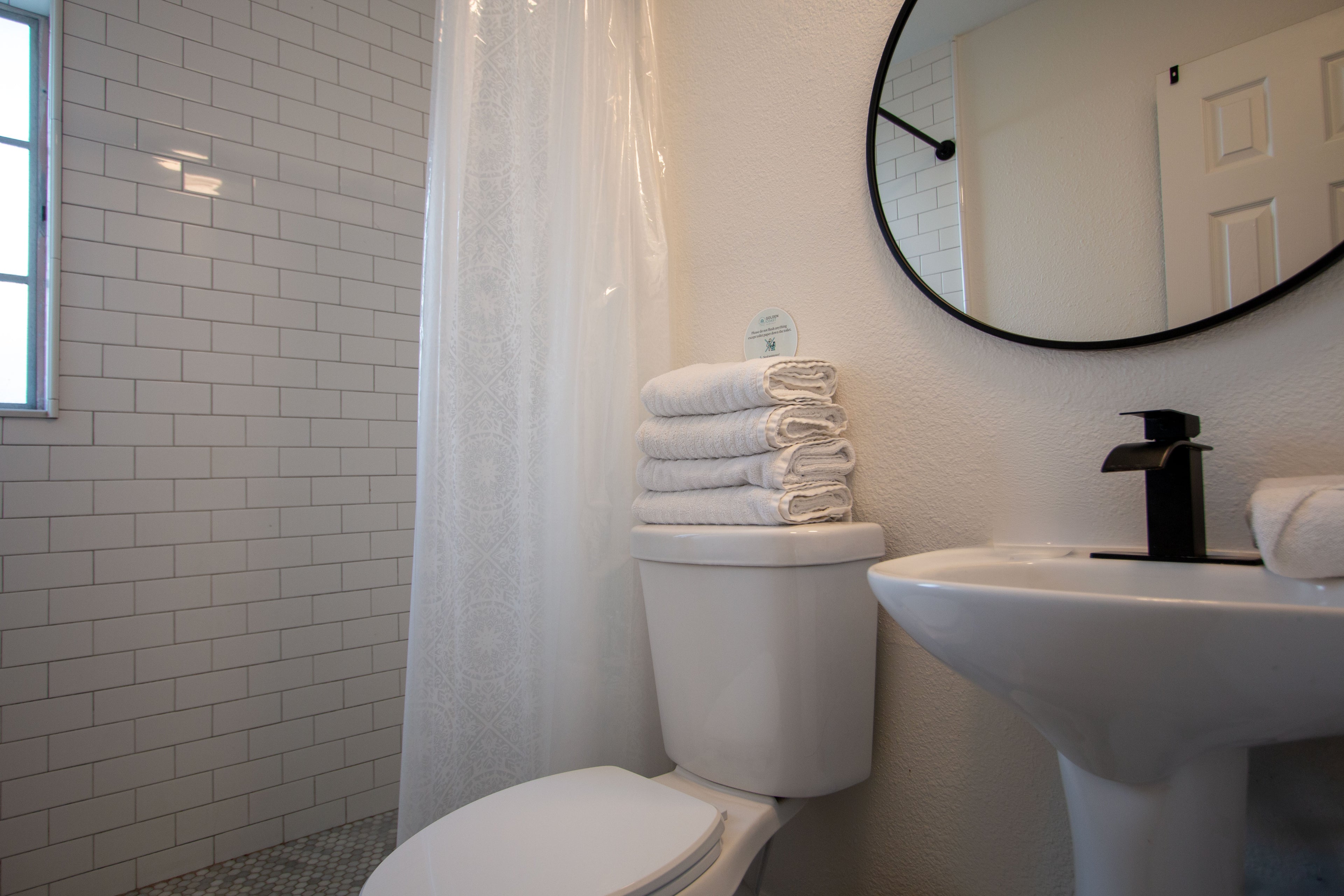 coastal bathroom at Sea Glass Beach Compound featuring walk-in shower, elegant vanity, bright natural lighting, and luxury Clearwater Beach vacation rental accommodations