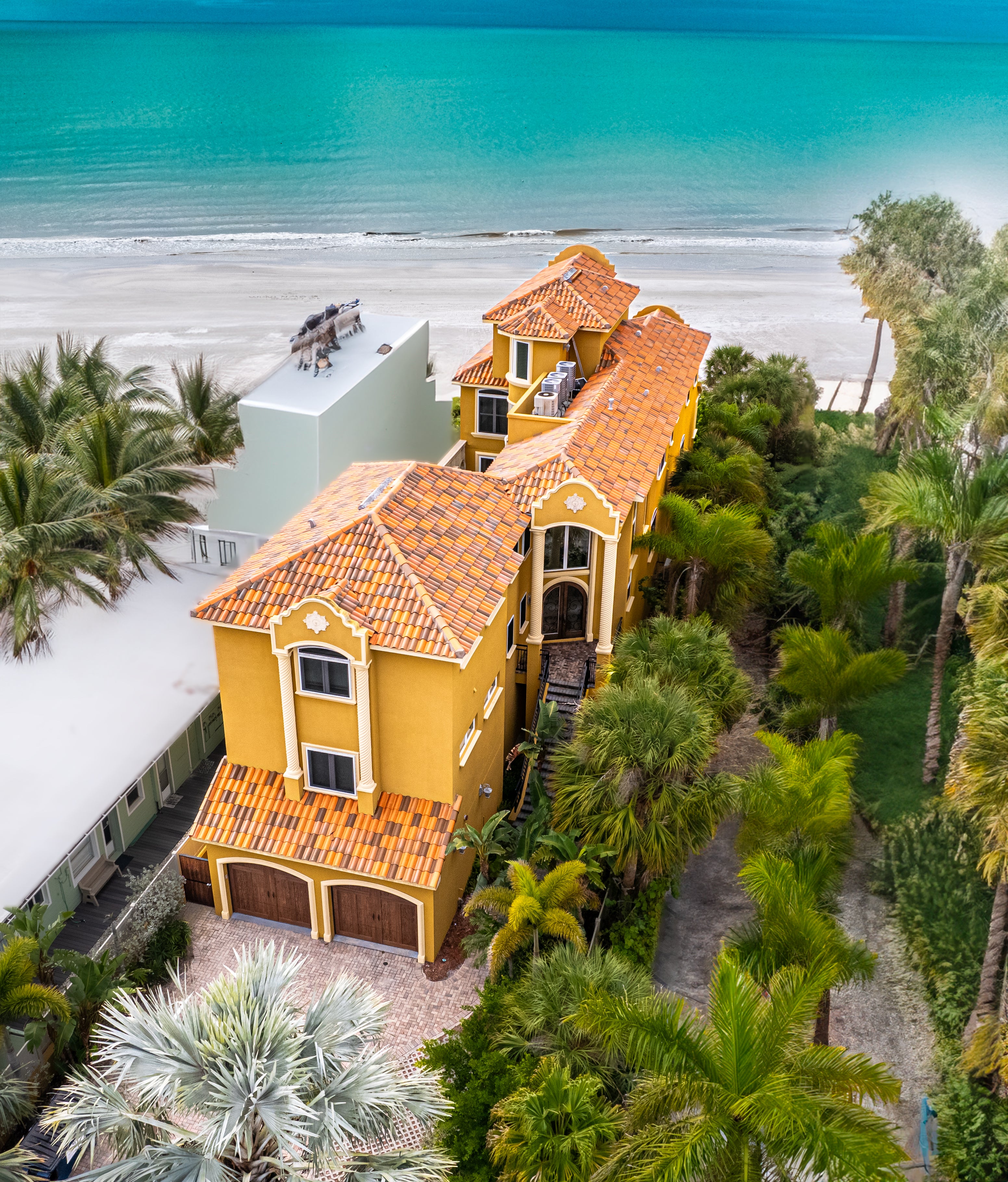 Mediterranean beachfront vacation home in Clearwater Beach featuring private beach access, tropical palm trees, oceanfront views, and spacious Gulf Coast vacation rental accommodations”